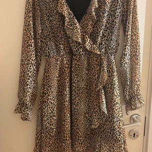 Leopardmönstrad klänning med volang - Jätte fin klänning med omlott design. Skulle säga att den passar storlek S-M.