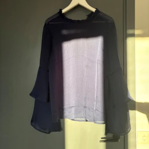 Mörkblå blus med volangärmar - Super fin mörkblå blus med långa, volangärmar. Nästan aldrig använd då den inte passar mig. Är i storlek 40🤗💗