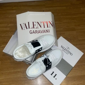 Valentino Garavani skor - Snygga Valentino Garavani sneakers i vitt med svarta detaljer. Skorna har en stilren design med snörning och är perfekta för en trendig look. Pris kan diskuteras vid snabb affär!!!