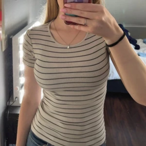 Vitt och svart randig t-shirt - Säljer denna T-shirt som inte används längre, köpt förra sommaren men inte använd mycket. Den vita färgen är lite mörkare/lite off white. Säljer billigt eftersom jag vill bli av med det💕