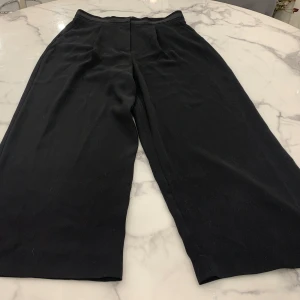 Svarta byxor från Tommy Hilfiger - Snygga svarta byxor från Tommy Hilfiger med en elegant design. Byxorna har en rak passform och är tillverkade i ett bekvämt material. 