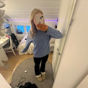 Blå tröja från Vero Moda - Mysig blå tröja från Vero Moda i en mjuk och bekväm design. Perfekt för kyligare dagar med sin långärmade stil och ribbade kanter. Enkelt att matcha med olika outfits.