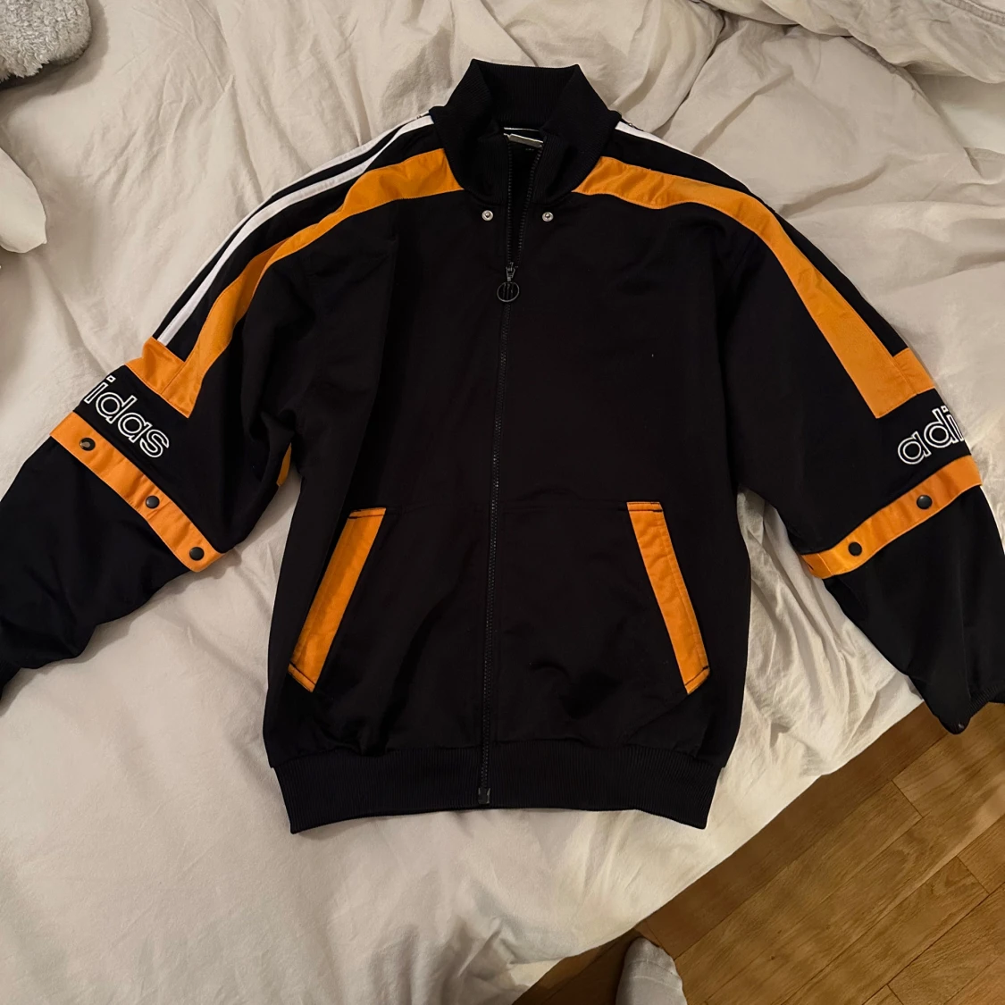 Svart och orange jacka från Adidas. Tunn. 