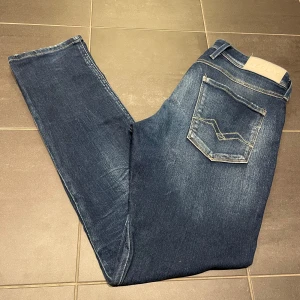Replay Anbass mörkblå - Ett par stilrena och väldigt populära jeans från Replay. Använda ca 3 gånger och är i ett väldigt bra skick. Modellen är ca 185 men saggar byxorna lite😆storlek 32W/32L. Sjukt sköna och sjukt snygga!