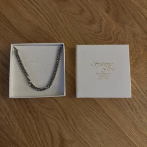 Silverfärgat halsband från Söbergs Guld - Elegant silverfärgat halsband från Söbergs Guld. Kedjan har en klassisk design med tätt sammanlänkade länkar och mäter cirka 45 cm i längd. Perfekt för att ge en stilren touch till din outfit. Finns även extra länkar till förlängning! Köpare står för frakt!