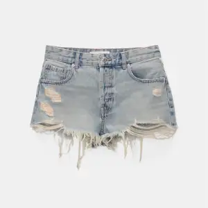 Säljer ett par snygga blå jeansshorts från Pull&Bear. De har en cool, sliten look med fransiga kanter och slitningar på framsidan. Perfekta för sommaren och ger en avslappnad stil. Aldrig använda, lapparna sitter kvar. 💞