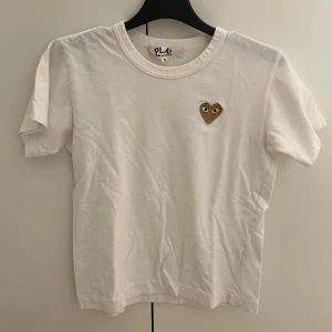 Tshirt - Vit T-shirt från comme des garcons  med guldglittrigt hjärta. Inte använd mycket och den passar både xs och s. 