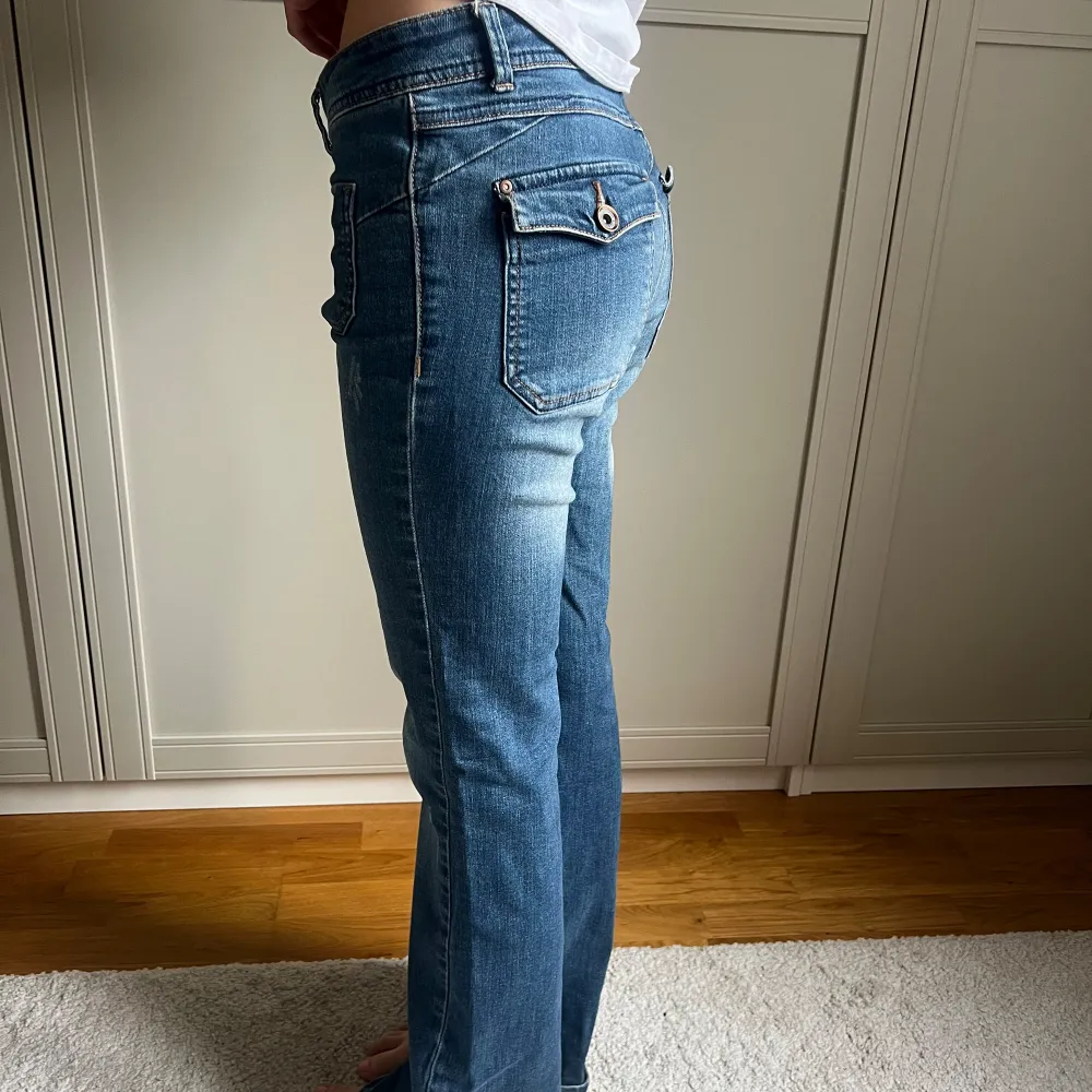 Snygga blåa bootcut jeans köpta second hand i Köpenhamn. Toppen skick och snygg modell med detaljer på bakfickorna💕. Jeans & Byxor.