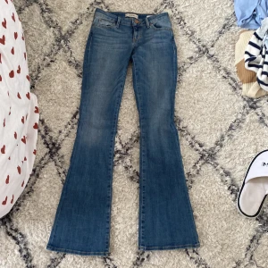 Blå jeans från Guess - Säljer ett par snygga blå jeans från Guess. De har en låg midja och en bootcut-stil. Jeansen är i klassisk blå denim och har det ikoniska Guess-märket på bakfickan. Köpta i Kanada för ungefär ett år sen för cirka 400kr på rea, original pris runt 800kr🙌🏼 Sparsamt använda och i väldigt bra skick💘 säljer pga de är för små i midjan. skriv gärna om ni har frågor!!🌟