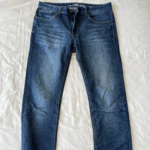 Blå jeans från Hampton Republic - Säljer ett par assnygga premium blå jeans från Hampton Republic i modellen Dave med slim fit. De är i storlek W31 L32 och är tillverkade av 96% bomull och 2% polyester, vilket gör dem både bekväma och hållbara. Perfekta för både vardag och fest! Frågor? Skriv!