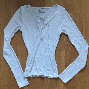 Vit tröja - Långärmad tröja från hollister, små färgfläckar på höger sida av bröstet annars i gott skick.