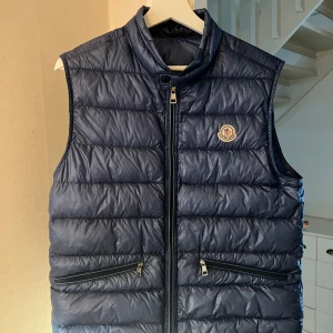 MONCLER GUI DOWN VEST BLÅ - Säljer nu denna feta väst, skön nu när de börjar bli kallare på kvällarna! Condition 8/10 använt mest på sena kvällar! Storlek S , tar även emot Byte ifall det är intressant! 