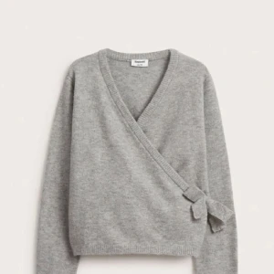 Grå omlott kofta från H&M - Säljer en mysig grå omlott kofta från H&M. Den har en knytning på sidan och är perfekt för kyliga dagar. Koftan har långa ärmar och en mjuk känsla. Passar bra till både jeans och kjol. Perfekt för höst och vinter! Oandvänd typ  storlek  158