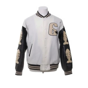 Vit och svart bomberjacka från HZQIFEI - Säljer en cool vit och svart bomberjacka från HZQIFEI. Jackan har svarta ärmar med beige fiskbensmönster och en stor broderad björn på ryggen. Framsidan pryds av ett stort 'G' och texten 'Flash Youth' på baksidan. Perfekt för en unik stil!