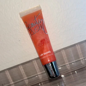 Victoria's Secret Beauty Rush Lip Gloss - Ny, i nyansen ”Mimosa me”.  ”The lip gloss you know and love, now with a sleek new look, gives your lips a sheer kiss of delicious color and shine. A supermodel essential, grab one for every bag.”