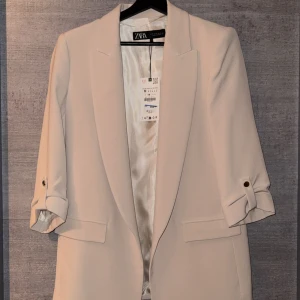 Beige kavaj från Zara - Snygg beige kavaj från Zara med trekvartsärmar och stilrena slag. 
