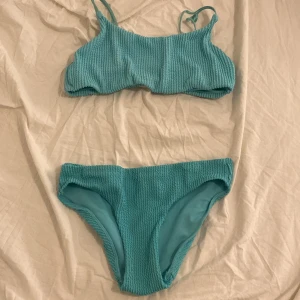 Turkos ribbad bikini - Snygg turkos bikini med ribbad textur. Toppen har smala axelband och en enkel design. Perfekt för en dag på stranden eller vid poolen. Passar 146-158 och mer för materialet är väldigt stretchiga 💕