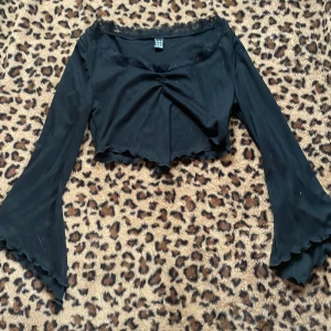 Svart långärmad topp med volang - Snygg svart topp med långa ärmar och volangdetaljer. 