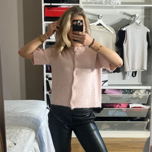 Rosa stickad kofta - Säljer en söt rosa stickad kofta med korta ärmar och knappar framtill. Perfekt för en mysig och stilren look. Passar bra till de flesta tillfällen🩷