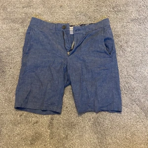 Dressman linne shorts - Säljer ett par riktigt feta linne shorts från dressman. De passar perfekt till sommaren och är i blå färg. Perfekt för en stilig sommar outfit. Hör av er vid funderingar!