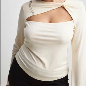 Beige långärmad topp med asymmetrisk design - Fin topp med en Knut detalj, använd nån enstaka gång så i väldigt bra skick  Strorlek L men är mer som en M, naturvit färg 