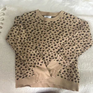 Beige leopardmönstrad tröja från Zara - Säljer en snygg beige tröja från Zara med leopardmönster. Tröjan har långa ärmar och ribbade muddar vid ärmslut och nederkant. Storlek 11-12 men passar som xs. Den sitter bra på mig och jag är 167. Kom privat för flera bilder