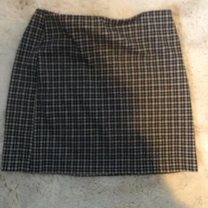 Rutig kjol från H&M Divided - Snygg rutig kjol från H&M Divided i svart och beige. Kjolen har en klassisk passform och är perfekt för en stilren look. Passar bra till både vardag och mer uppklädda tillfällen. Säljer då det inte är min stil längre. Den är endast testad och prislappen sitter kvar