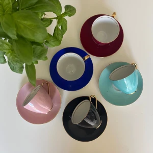 Färgglada espressokoppar med fat - Säljer ett set med fem espressokoppar och matchande fat i olika färger: vinröd, blå, turkos, rosa och svart. Kopparna har eleganta guldfärgade handtag som ger en lyxig känsla. Perfekt för att liva upp kaffestunden med lite färg och stil.