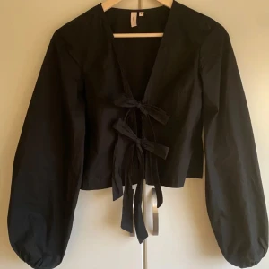 Nelly blus - Blus från Nelly med rosett knytning framtill. Blusen har långa puffiga ärmar. Köpt för 299kr. Skicket är som nytt då den är nästintill oanvänd, använd 1 gång. Storlek 34 ✨🎀💕