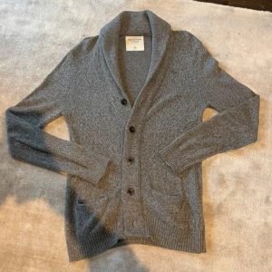 Grå cardigan Abercrombie & Fitch - Säljer en stilren grå cardigan  från Abercrombie & Fitch. Riktigt fint skick | Storlek: M, men passar L. Från 186cm & uppåt passar denna perfekt | Nypris: 700kr, vårat 299kr | Hojta till om du undrar över något !