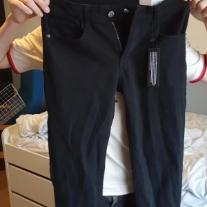 Svarta jeans byxor  - Snygga svarta byxor med rak och baggy form. Stor för storleken och ljus svarta. Köpta helt nya med prislapp. Jeans kostymbyxor inga defekter och ser inte alls använda ut perfekt tillstånd. 