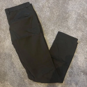 Gröna chinos från Boss - Snygga gröna chinos från Boss med en klassisk design. Byxorna har en normal passform och är tillverkade i bomull. De har knappar och dragkedja framtill samt fickor både fram och bak. Perfekta för en stilren look.