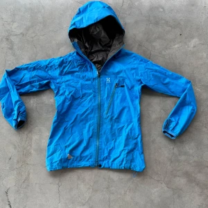 Windbreaker från Haglöfs - Säljer en blå windbreaker från Haglöfs med huva och dragkedja🔥 Den är i storlek XS🤩🎉 Den är lite liten på mig och jag är 175!👍 Vid minsta fundering kontakta mig🔥