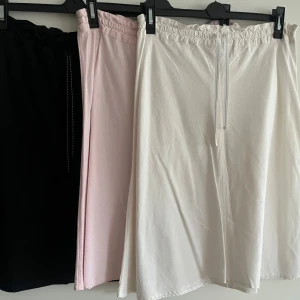 Tre kjolar i olika färger - Säljer tre snygga kjolar i svart, rosa och vit. Kjolarna har en bekväm resår i midjan och är gjorda i ett mjukt material. Perfekta för en avslappnad stil. Köp en för 70kr och alla 3 för 170kr