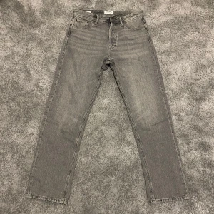 Grå jeans från Jack & Jones - Snygga grå jeans från Jack & Jones i modellen Relaxed/Chris. De har en klassisk femficksdesign och är tillverkade i ett slitstarkt denimtyg. Perfekta för en avslappnad stil med en rak passform.