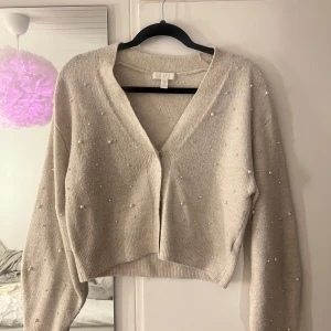 Beige kofta från H&M - Söt kofta med pärldetaljer, V ringad och jättebra skick
