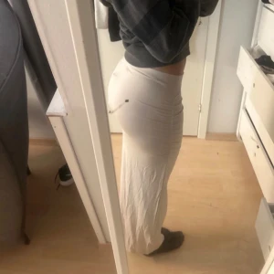 Lång kjol  - Säljer en skön och stilren kräm kjol från Gina Tricot. Kjolen har en tight passform och är tillverkad i ett stretchigt material, helt ny med prislapp kvar 