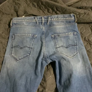 Blå jeans från Replay - Snygga blå jeans från Replay med slitna detaljer och en slim passform. Storlek 166 men passar även 170 och 175. Nästan helt oanvända, Tveka inte på att höra av er!