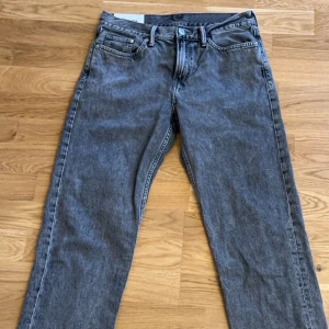 Grå jeans från H&M - Säljer ett par grå jeans från H&M i relaxed fit. De har en klassisk femficksdesign och är tillverkade i ett slitstarkt material. Perfekta för en avslappnad stil. Använda fåtal gånger