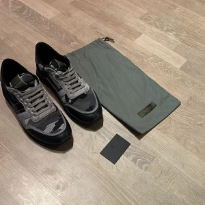 Valentino rockrunners - Säljer ett par snygga Valentino sneakers i grått och svart. De har en cool camo-design och är i mycket bra skick.  Skorna kommer med en praktisk förvaringspåse.