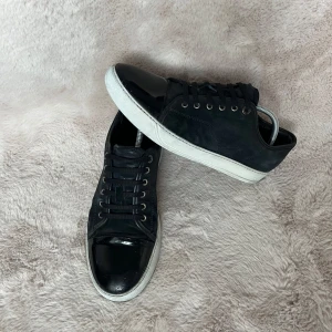 Lanvin skor - Säljer ett par svarta sneakers från Lanvin i ganska bra skick. Skorna är i storlek 43 och är marinblåa(navyblue). Dessa skor passar allting då färgen kan kombineras med andra färger.