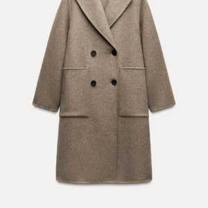 Zara mink ull kappa helt oanvänd - Säljer en stilren beige kappa i ull med dubbelknäppning och stora fickor. Perfekt för höst och vinter, med en klassisk design som passar till allt. Kappan har långa ärmar och en bekväm passform. Ett måste i garderoben för den som vill hålla sig varm och snygg!