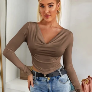 Brun långärmad topp🤎 - Snygg brun långärmad topp med draperad v-ringning. Materialet är mjukt och stretchigt, vilket gör den bekväm att bära hela dagen. Storlek M,skriv för fler bilder 🥰