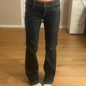 Svarta jeans med bootcut - Säljer ett par snygga svarta jeans med bootcut. De har låg midja och coola detaljer med kontrastsömmar. Mycket fint skick!!