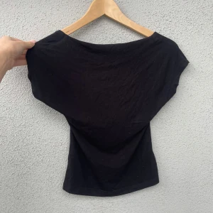 Svart öppenrygg t-shirt  - Hejj! Säljer denna superfina t-shirten med öppen rygg. Tröjan har en jättefin passform och är otroligt skön att ha på sig. Jag köpte denna tröjan för ett par månader sedan men den är knappast använd, därav inga defekter på den. Hör mer än gärna av er om ni skulle ha några frågor! 