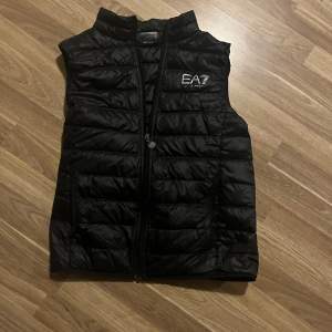 Snygg svart dunväst från EA7 Emporio Armani. Storlek m. Pris 650 kr men kan diskuteras vid snabbt köp. 