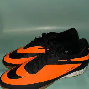 Säljer ett par Nike Hypervenom storlek 45 men passar bra 44 fotbollsskor i svart och orange. Skorna har en snygg design med snörning och är perfekta för inomhusfotboll. De är i bra skick med en slitstark sula som ger bra grepp på planen.