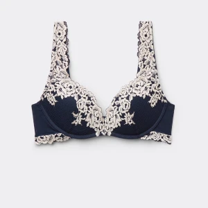 Mörkblå bh med spetsdetaljer - Elegant mörkblå bh med vackra spetsdetaljer i krämfärg. Perfekt för en lyxig känsla under kläderna. Den har justerbara axelband och en bekväm passform. Perfekt för både vardag och speciella tillfällen.