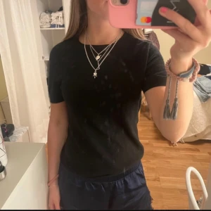 Svart kortärmad tröja i cashmere  - Säljer en stilren svart kortärmad tröja i kashmir. Perfekt för både vardag och fest! Tröjan har en normal passform och är gjord i ett mjukt material som känns skönt mot huden. Ett måste i garderoben för alla säsonger. 🖤