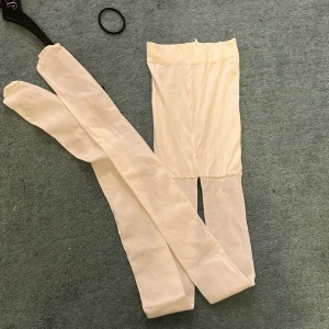 Vita strumpbyxor - Säljer ett par vita strumpbyxor i nytt skick. De är tunna och elastiska, perfekta för att bära under klänningar eller kjolar. Passar bra till både vardag och fest, använda en gång. Hör av dig vid intresse!